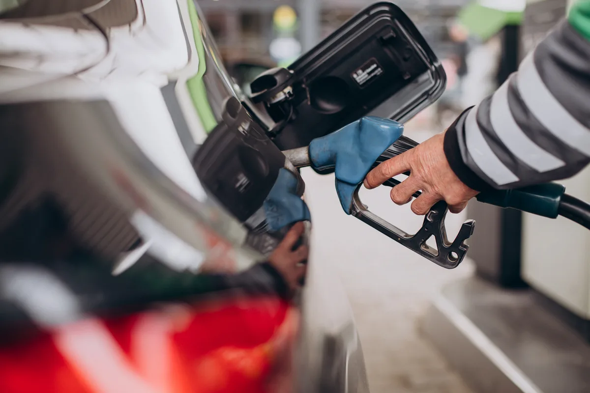 Persona repostando combustible en una gasolinera